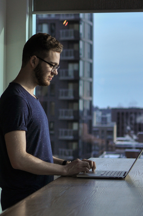 Image of guy standing in front of a laptop